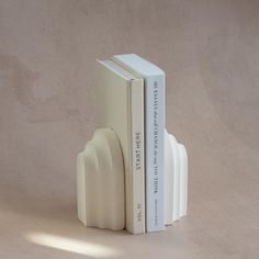 two books are stacked on top of each other in the shape of a bookend