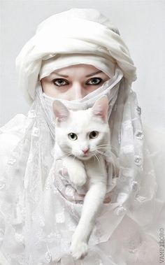 a woman wearing a veil holding a white cat in her arms with the caption, posted on simply beautiful