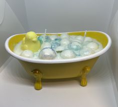 a yellow bath tub filled with soap balls