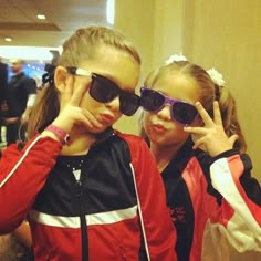 two girls wearing sunglasses are posing for the camera