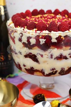 a dessert with raspberries and whipped cream in a glass dish on a table