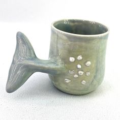 a ceramic fish shaped cup sitting on top of a table