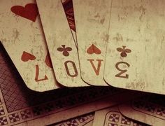 several playing cards are stacked on top of each other with the word love spelled in black and white