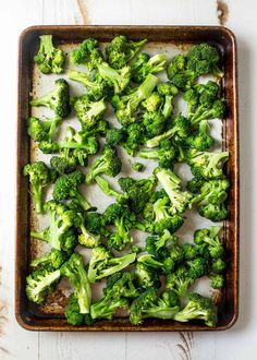 broccoli florets in a baking dish on a white wooden table top