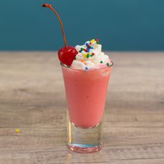 a drink with whipped cream, sprinkles and a cherry on the top