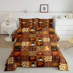 a bed covered in brown and orange quilts next to a night stand with a lamp