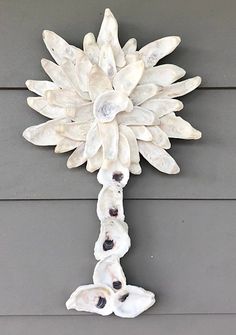 a white flower shaped object hanging on the side of a building