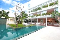 an outdoor swimming pool next to a large white building