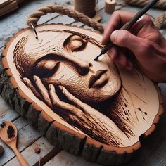 a person holding a pen and drawing on a piece of wood that looks like a woman's face