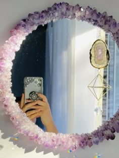 a woman taking a selfie with her cell phone in front of a circular mirror