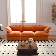 an orange couch sitting on top of a black and white floor next to a coffee table