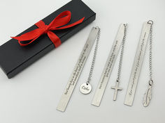 four personalized necklaces in a gift box with a red ribbon tied around them