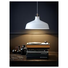 an old typewriter sitting on top of a wooden table next to a white lamp