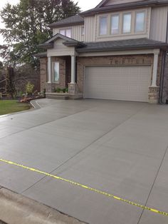 a driveway with yellow tape on it and a house in the background