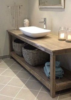 a bathroom with a sink and two baskets on the counter next to it is lit by candles