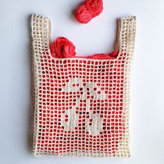 a crocheted bag with two balls of yarn in the front and on the back