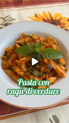 pasta con ragi di verdure on a white plate with green leafy garnish