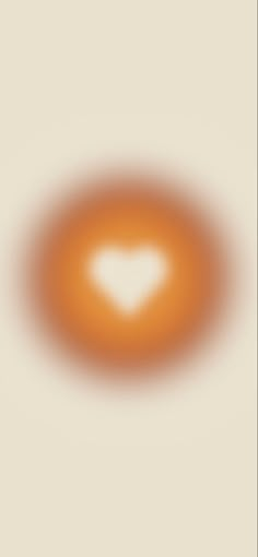 an orange circle with a white heart in the center on a beige background that appears to be blurry