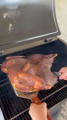 someone is grilling a large piece of meat on an outdoor grill