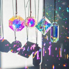 three different colored crystals hanging from strings