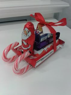 candy canes, candy bar and santa clause bag sitting on top of a table