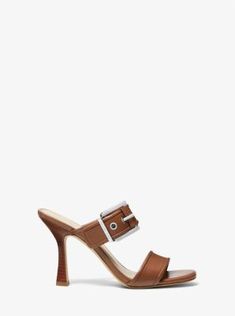 Featuring a polished buckle strap, the Colby heeled sandal is a slightly edgier take on the always-classic mule. Crafted from buttery-smooth leather, it’s designed with two thick straps and set on a sculptural fluted heel. Wear them day or night, with everything from oversized denim to a flirty dress. Brown Party Mules With 4-inch Heel, Brown Open Heel Sandals With Cork-bed Midsoles, Brown Wedge Heel Mules With Cork-bed Midsoles, Brown Leather T-strap Sandals With Buckle Closure, Brown Synthetic Wedge Sandals With 4-inch Heel, Luggage Sizes, Mule, Flirty Dresses, Michael Kors Collection