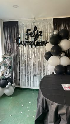 black and white balloons are on display in front of a backdrop that reads follz cumplan