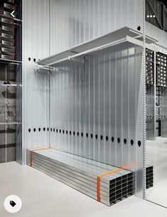 the inside of a large storage room with metal shelving and orange bars on each side