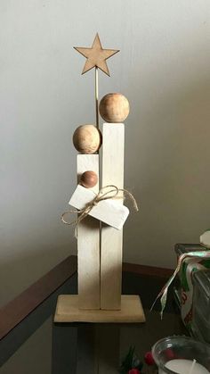 a wooden sculpture with two balls and a star on top