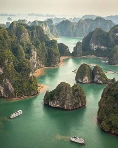 an aerial view of several boats in the water surrounded by green hills and islands with trees