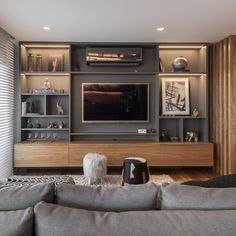 a living room with grey couches and entertainment center