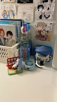 there are many items on the counter in this office space, including water bottle and books