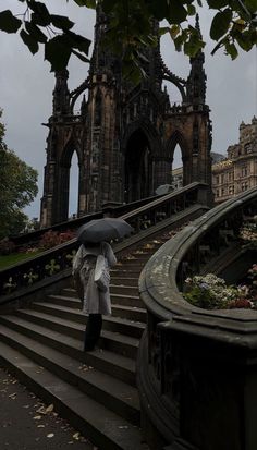 a person with an umbrella walking up some stairs in front of a building on a cloudy day