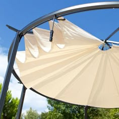 a large white umbrella sitting under a blue sky