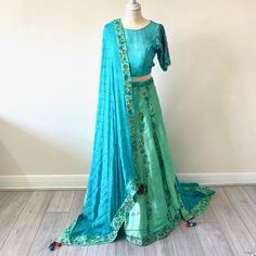 .Beautiful dupatta in a pure georgette turqoise fabric with sea green silk boarder with intricate hand embroidery  .Raw silk turquoise blouse with fully hand embroidered sleeves .Back of this unique backless design choli blouse in raw silk turqoise material .A unique custom made lahenga in sea green and turquoise raw silk material and georgette dupatta. All the work is fully hand embroidered . A vibrant raw silk lahenga in a turquoise and sea green colour with full hand embroidery Turquoise Sharara With Dupatta Traditional Drape, Traditional Turquoise Sharara With Dupatta, Bollywood Turquoise Saree Set, Turquoise Sharara With Zari Work, Green Silk Choli With Dupatta, Green Silk Bollywood Choli, Semi-stitched Turquoise Sets With Dupatta, Festive Turquoise Sharara With Resham Embroidery, Bollywood Style Turquoise Dupatta With Resham Embroidery