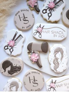 decorated cookies with scissors and hair stylist's names are on a table