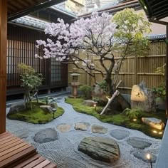 a japanese garden with rocks and trees in the center, lit up by lights from lanterns