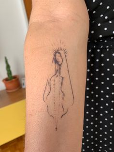 a woman's arm with a tattoo on it that has a drawing of a person