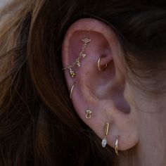 a woman wearing three different ear piercings