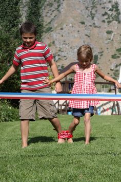 two young children holding a blue and red ribbon