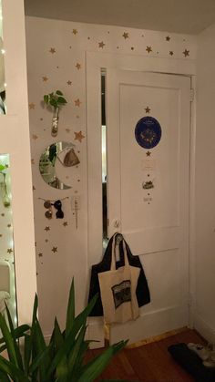 a white door with stars on the wall and a black bag hanging from it's side