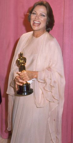 an old photo of a woman holding her oscar for best supporting actress in a motion