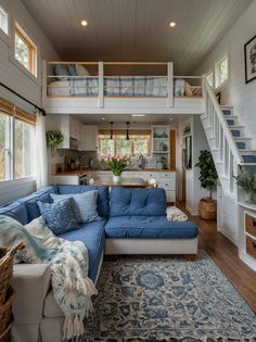 a living room filled with furniture and a blue couch in front of a stair case