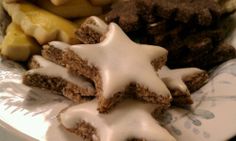 a plate topped with cut up cookies covered in icing next to other food items