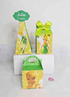 three small boxes with tinkerbells on them, one is green and the other is yellow