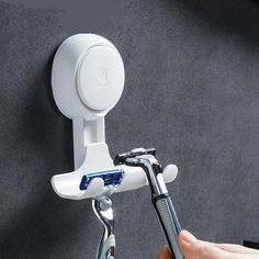 a person is holding a toothbrush in front of a wall mounted hair dryer