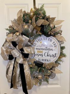 a christmas wreath hanging on a door with the words built in the mountain jesus christ is born