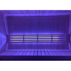 the inside of a wooden sauna with purple light coming from it's sides