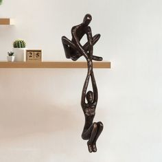 a metal sculpture sitting on top of a wooden shelf