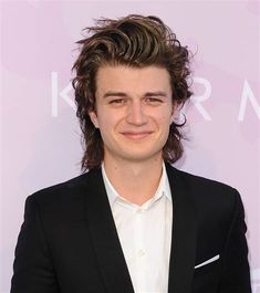 a young man in a black suit and white shirt